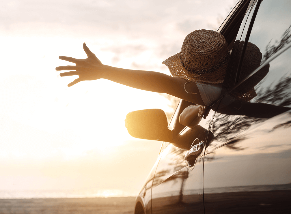 車の窓から手を伸ばす女性