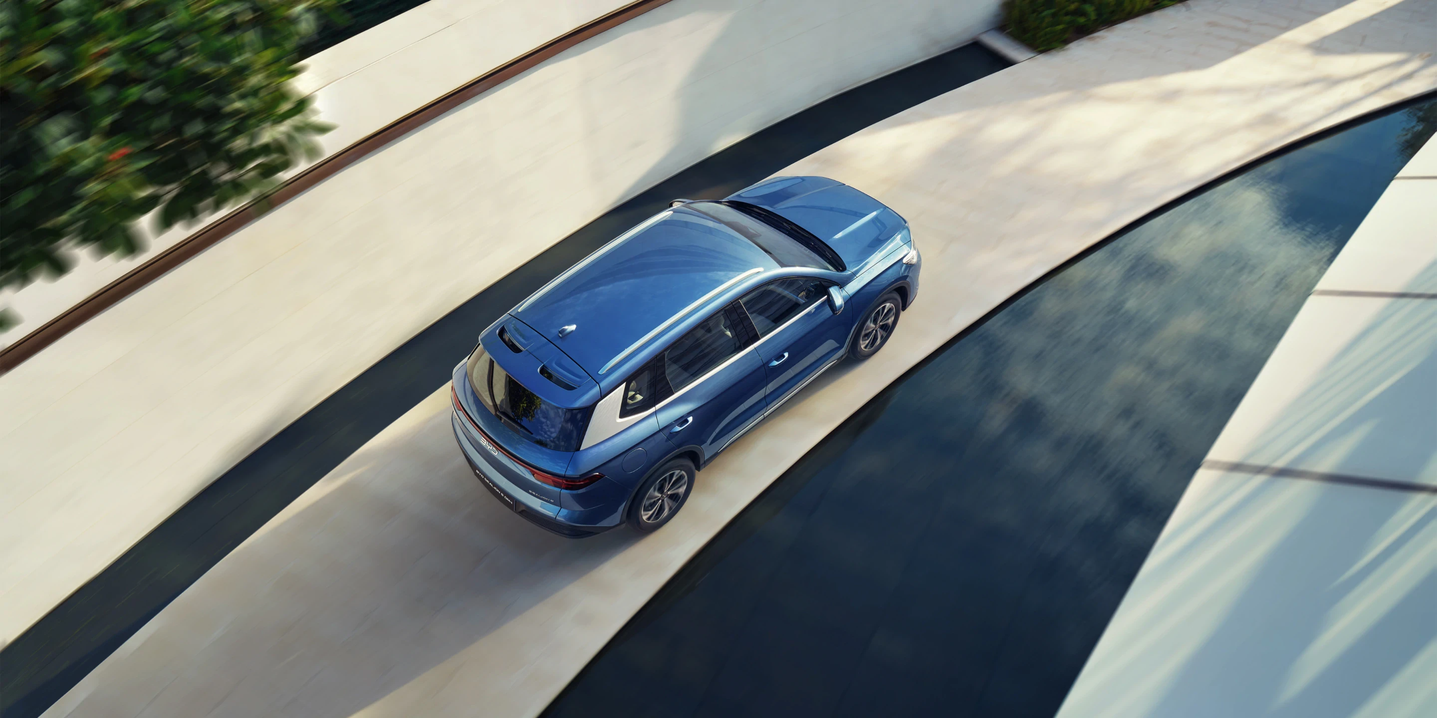 BYD Sealion 5 DM-i driving on a scenic road showcasing its smooth hybrid driving experience